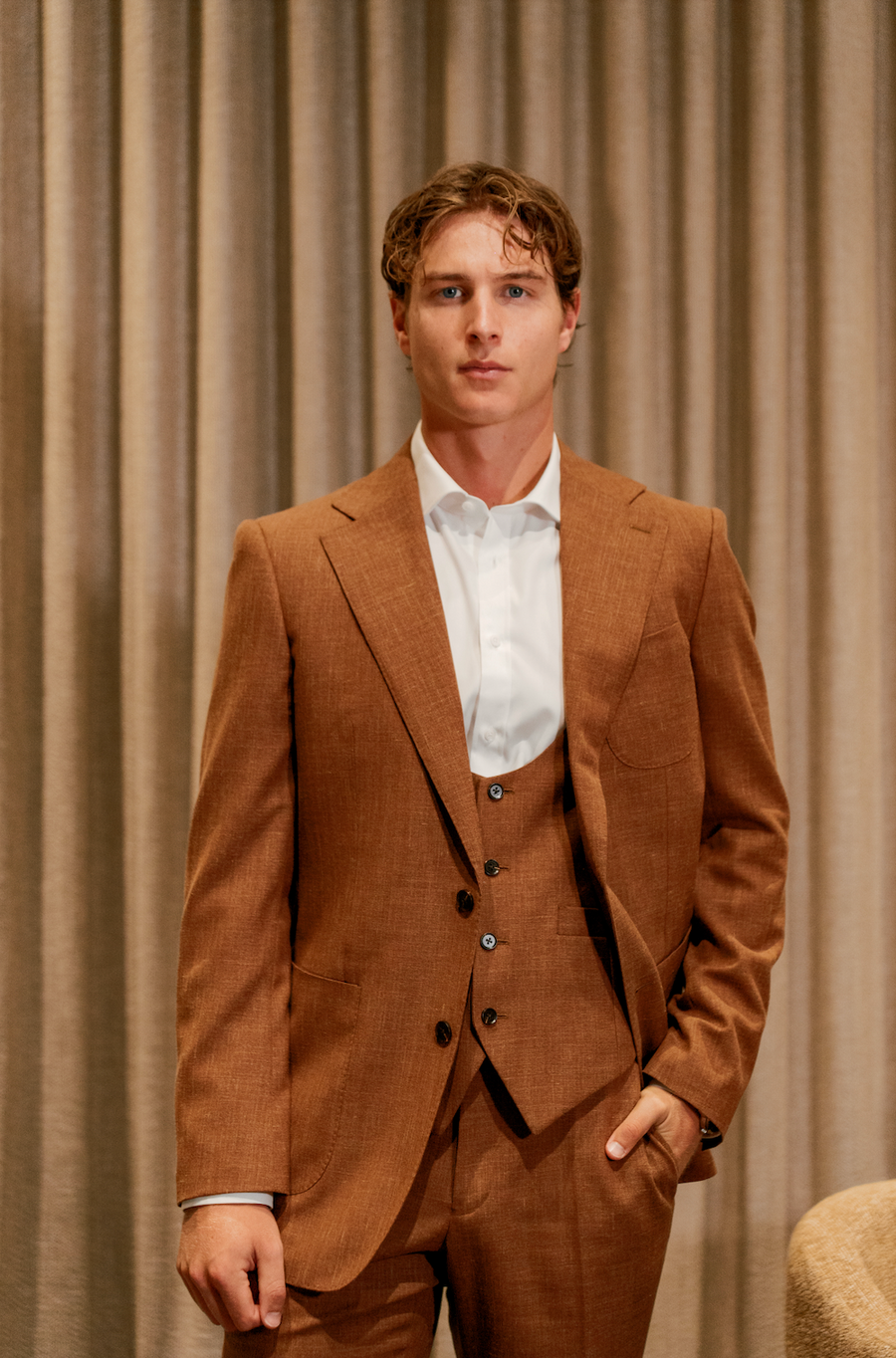 male wearing a more casual brown suit often referred to as the colour rust before he gets married.